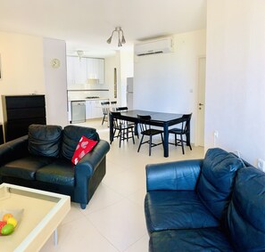 Departamento Confort, vista a la ciudad | Área de sala de estar | Televisión de pantalla plana 