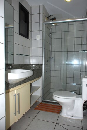 A bathroom with a white sink, toilet, and shower. - Altavista Apartments (Fortaleza)