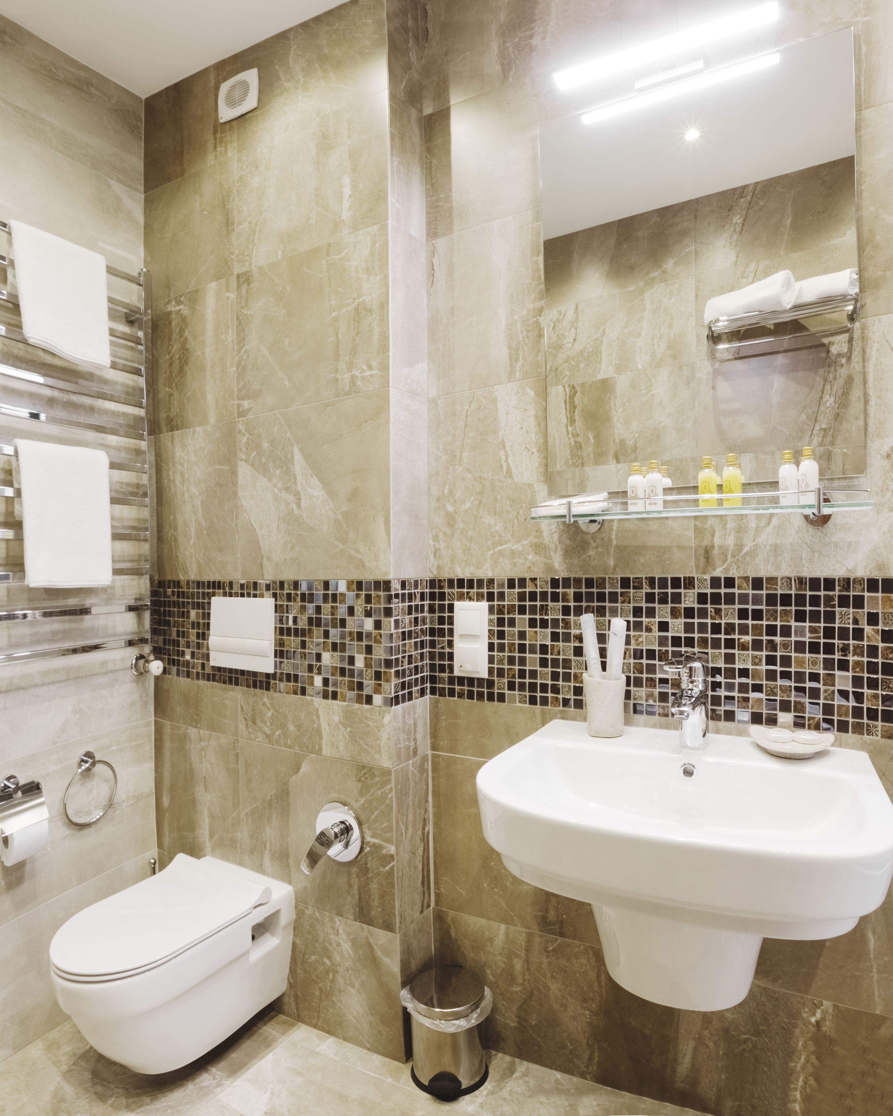 A modern bathroom with a toilet, sink, and towel rack.