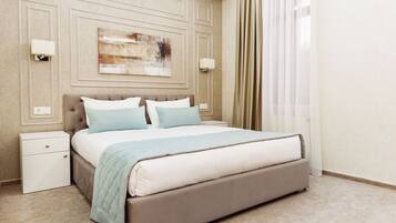 A neatly arranged hotel room with a large bed, a bedside table, and a wall-mounted artwork.