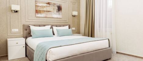A neatly arranged hotel room with a large bed, a bedside table, and a wall-mounted artwork.
