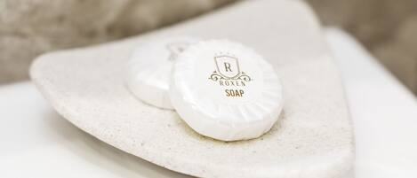 A soap bar with a logo on a white, textured surface.