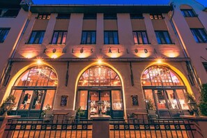 Un edificio con ventanas de arco y un cartel que dice 'KOMLOSTALOD'.