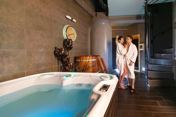 A spa area with a hot tub, a clock, and a staircase.