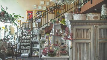 A spacious, well-lit interior with a staircase leading to an upper level, decorated with various home decor items and framed artwork.