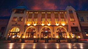 A building with arched entrances and a sign reading "Komlószálloda".