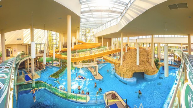 An indoor water park with multiple slides and pools.