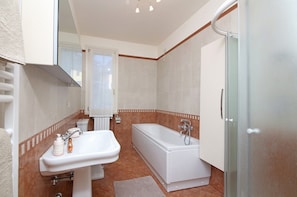 Un baño con lavamanos, inodoro y bañera.