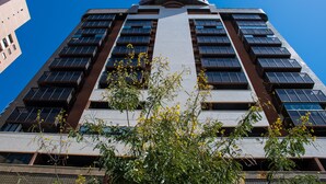 Ein Hochhaus mit mehreren Stockwerken, großen Fenstern und einem zentralen vertikalen Element.