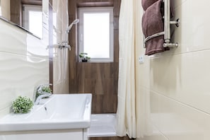 Studio | Badkamer | Een douche, een haardroger, pantoffels, zeep