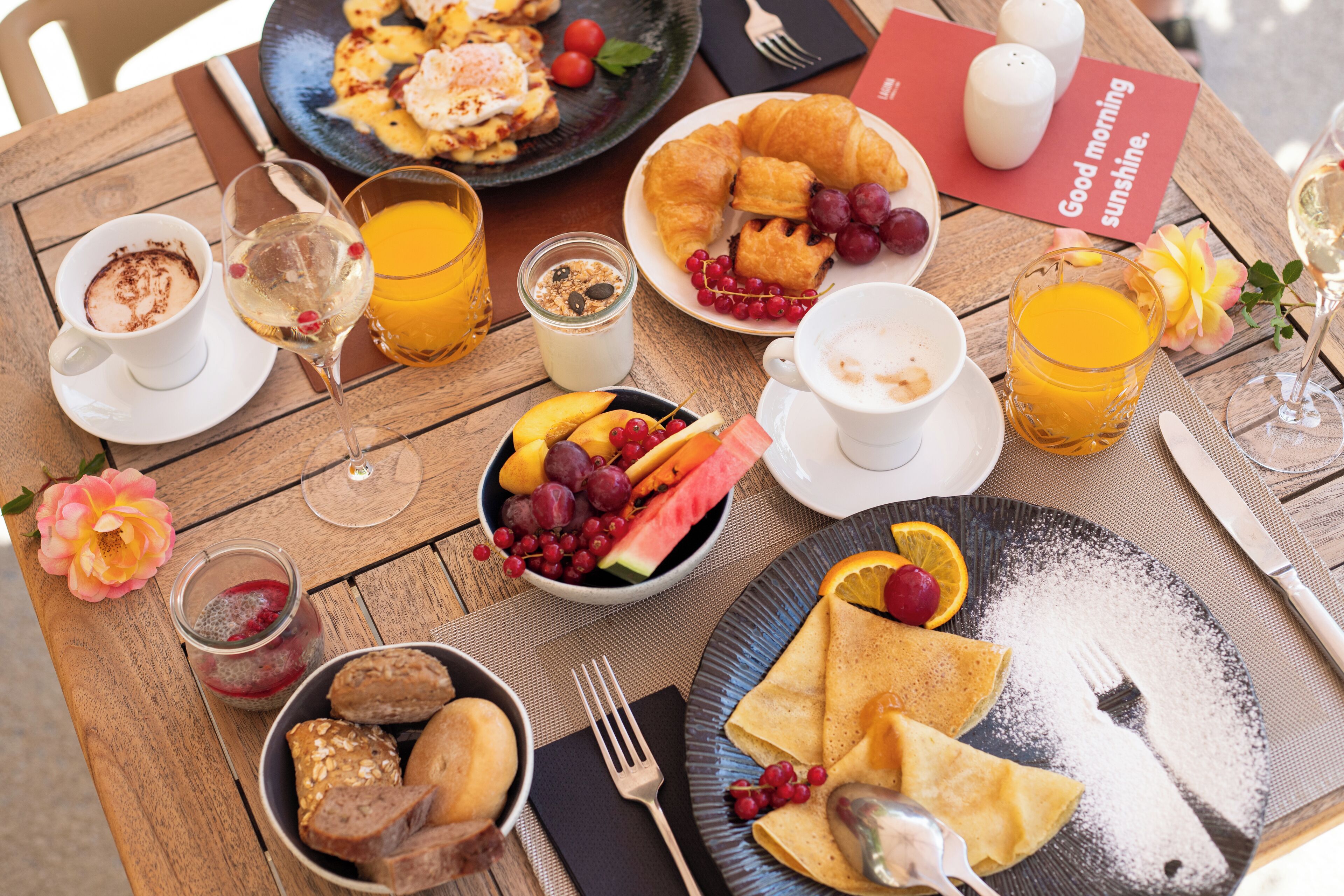 Taula de petit esmorzar amb croissants, fruita i begudes.