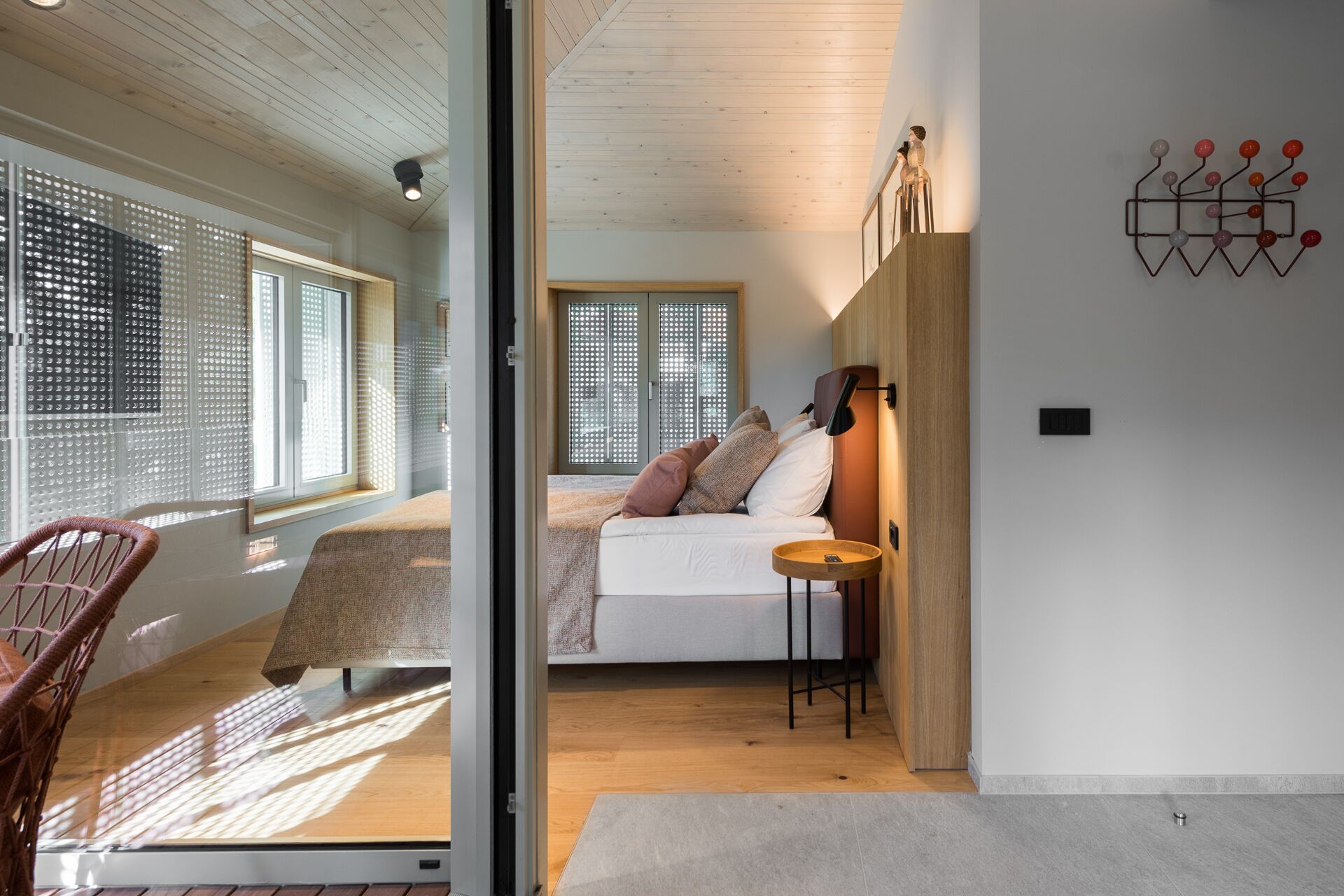 A modern bedroom with a bed, a chair, and a small table.