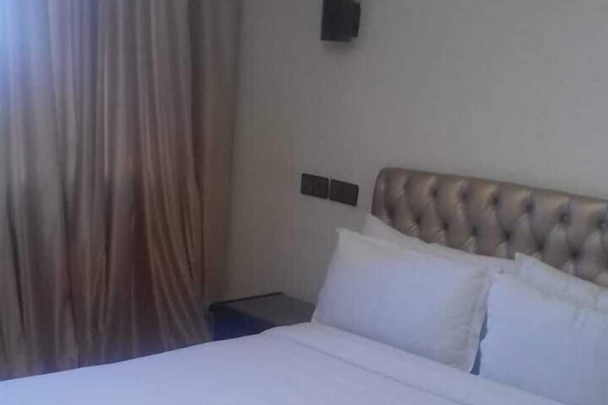 Ein ordentlich bezogenes Bett mit weißen Leinentüchern in einem Hotelzimmer.