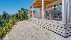 Ein Holzhaus mit überdachter Veranda und einem Kiesweg.