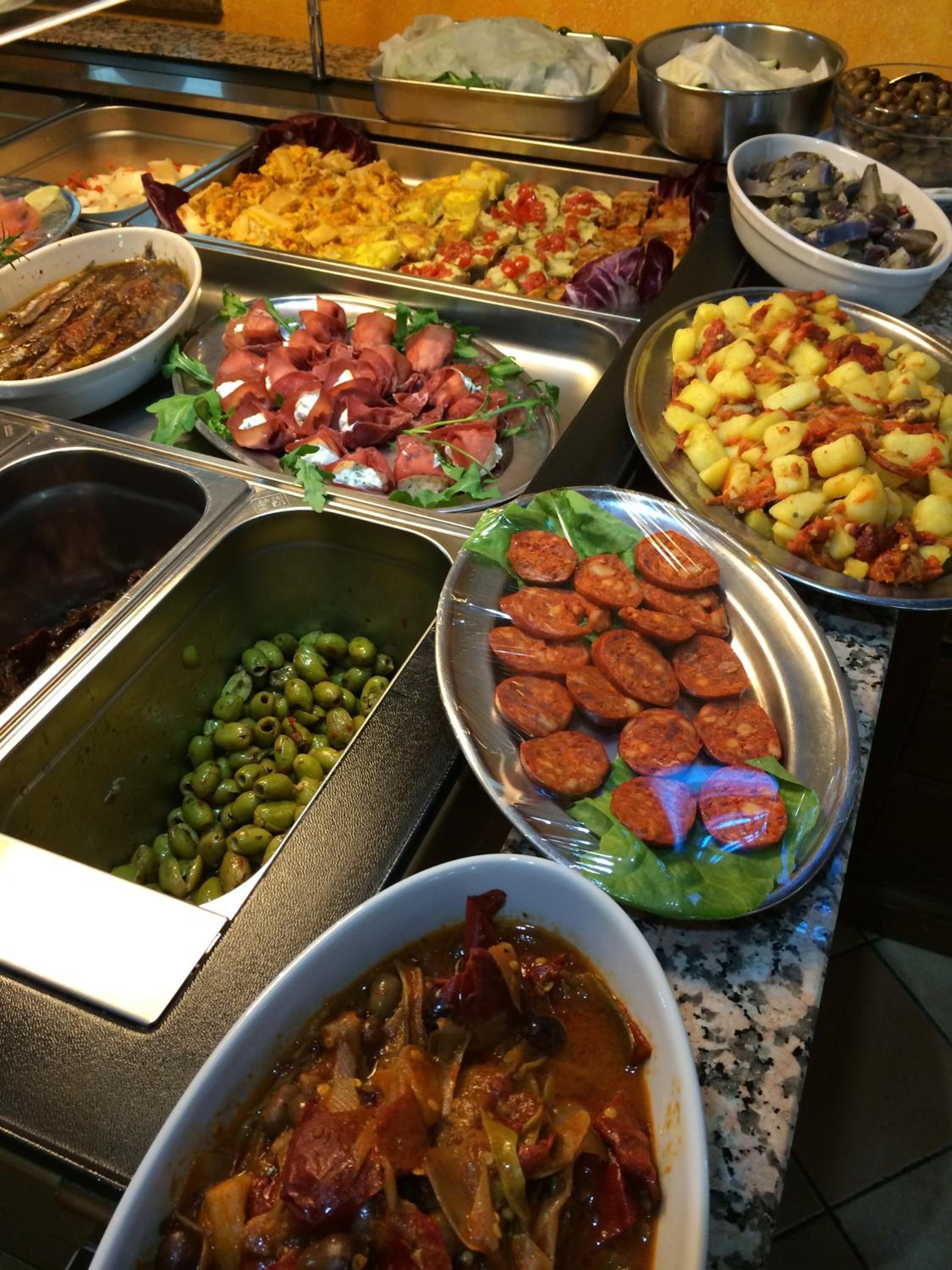Een buffet met verschillende soorten eten, zoals vlees, groenten en salades.