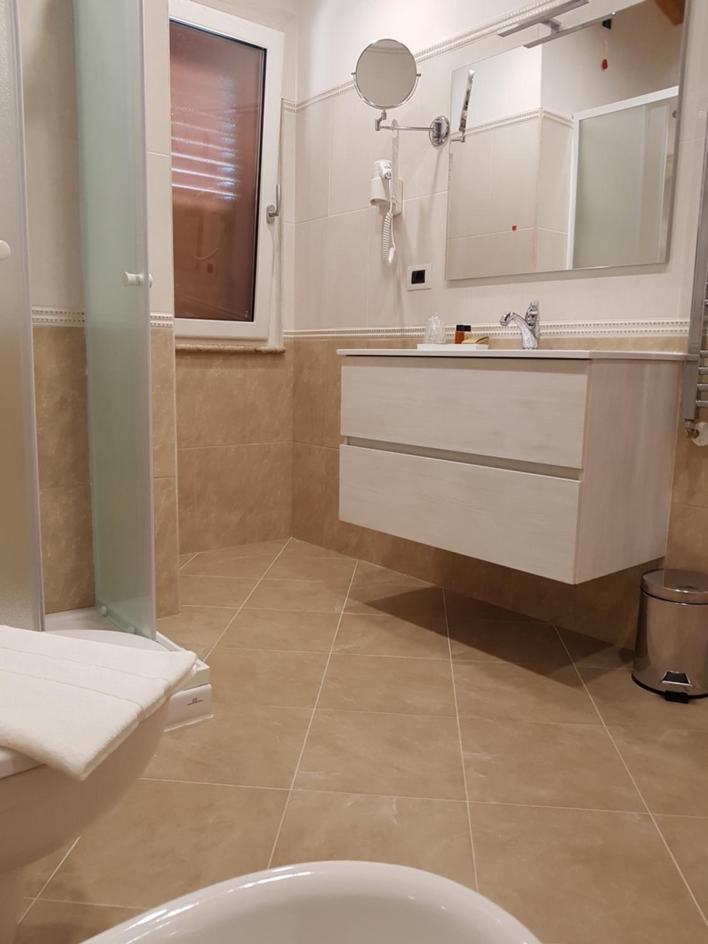 A bathroom with a bathtub, a vanity with a mirror, and a toilet.