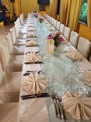 A long banquet table set with folded napkins, cutlery, and glassware, likely prepared for a formal event. - B&B San Pietro (Mileto)