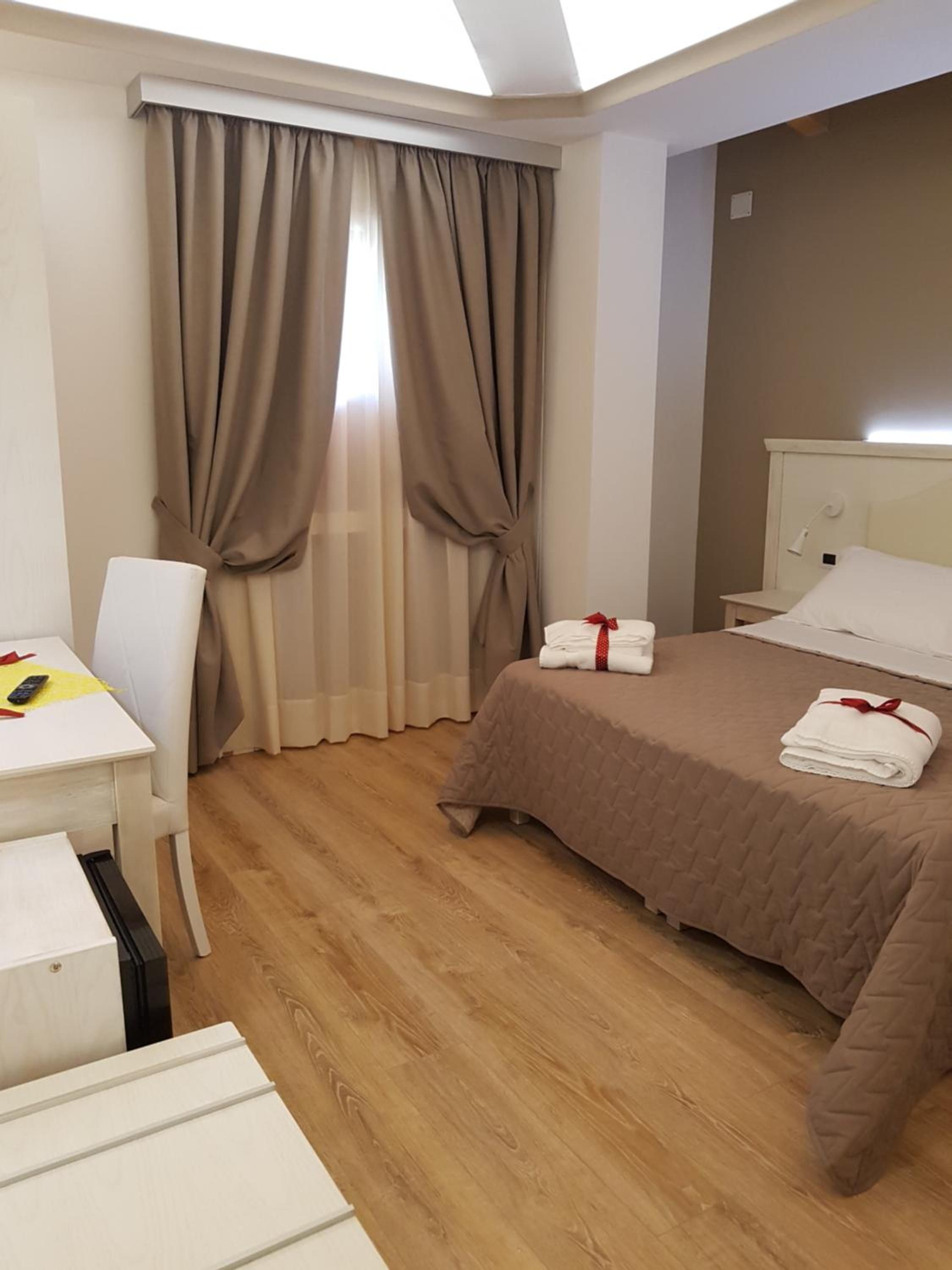 Une chambre d’hôtel avec un lit, un bureau et une chaise.