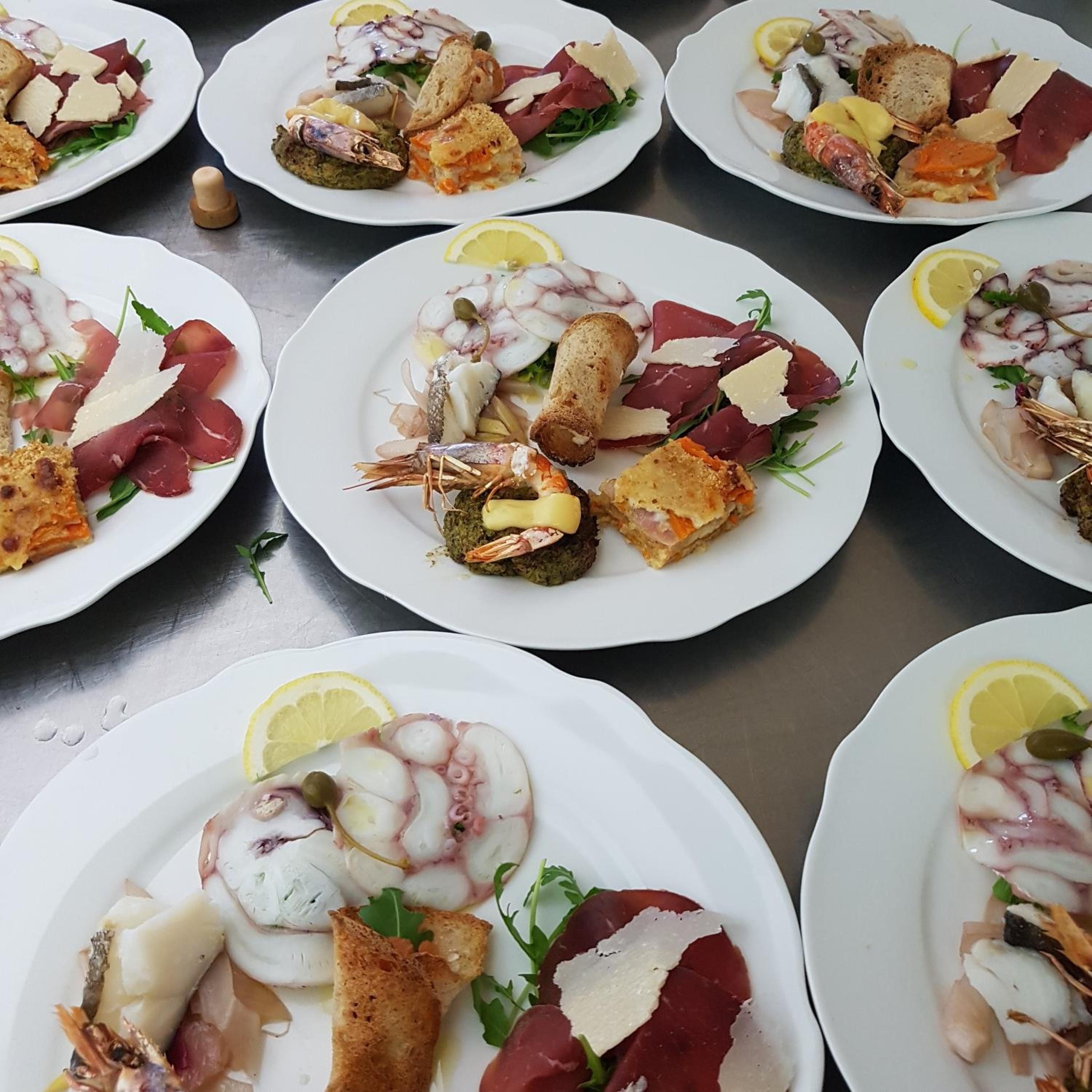 Multiple plates of seafood dishes with various accompaniments.