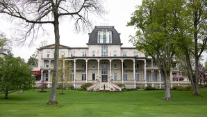 A large, stately building with a symmetrical facade, a central entrance with steps, and a formal front porch. - Athenaeum Hotel (Mayville)