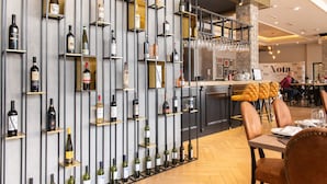 Ein Restaurantinneres mit Weinständen, Holztischen und -stühlen.