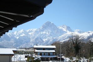 A traditional building with a snow-covered roof, set against a backdrop of snow-capped mountains. - La Villetta sul Mavone (Colledara)