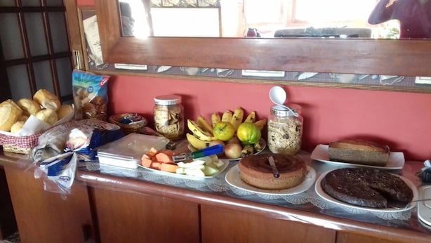 Mostrador de buffet con diversas opciones de comida, incluyendo pan, frutas y postres.
