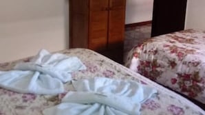 Un dormitorio con dos camas, un armario de madera y un cuadro en la pared.