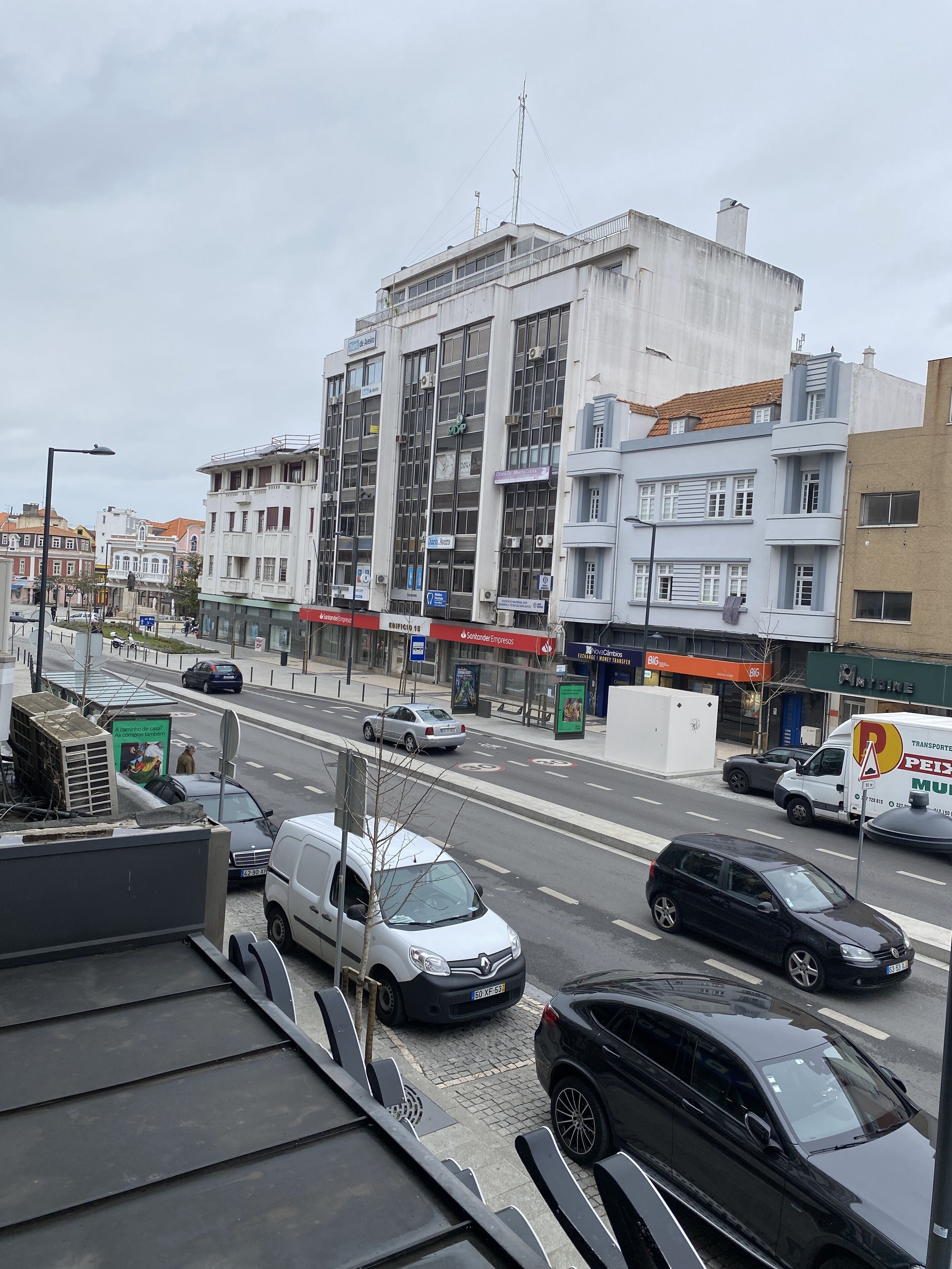 A street view with buildings, cars, and a bus stop.