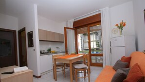 A compact living space with a kitchen, dining area, and a sofa.