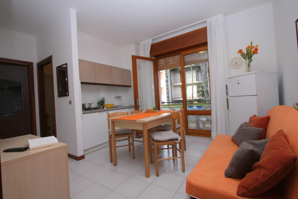 A compact living space with a kitchen, dining area, and a sofa.