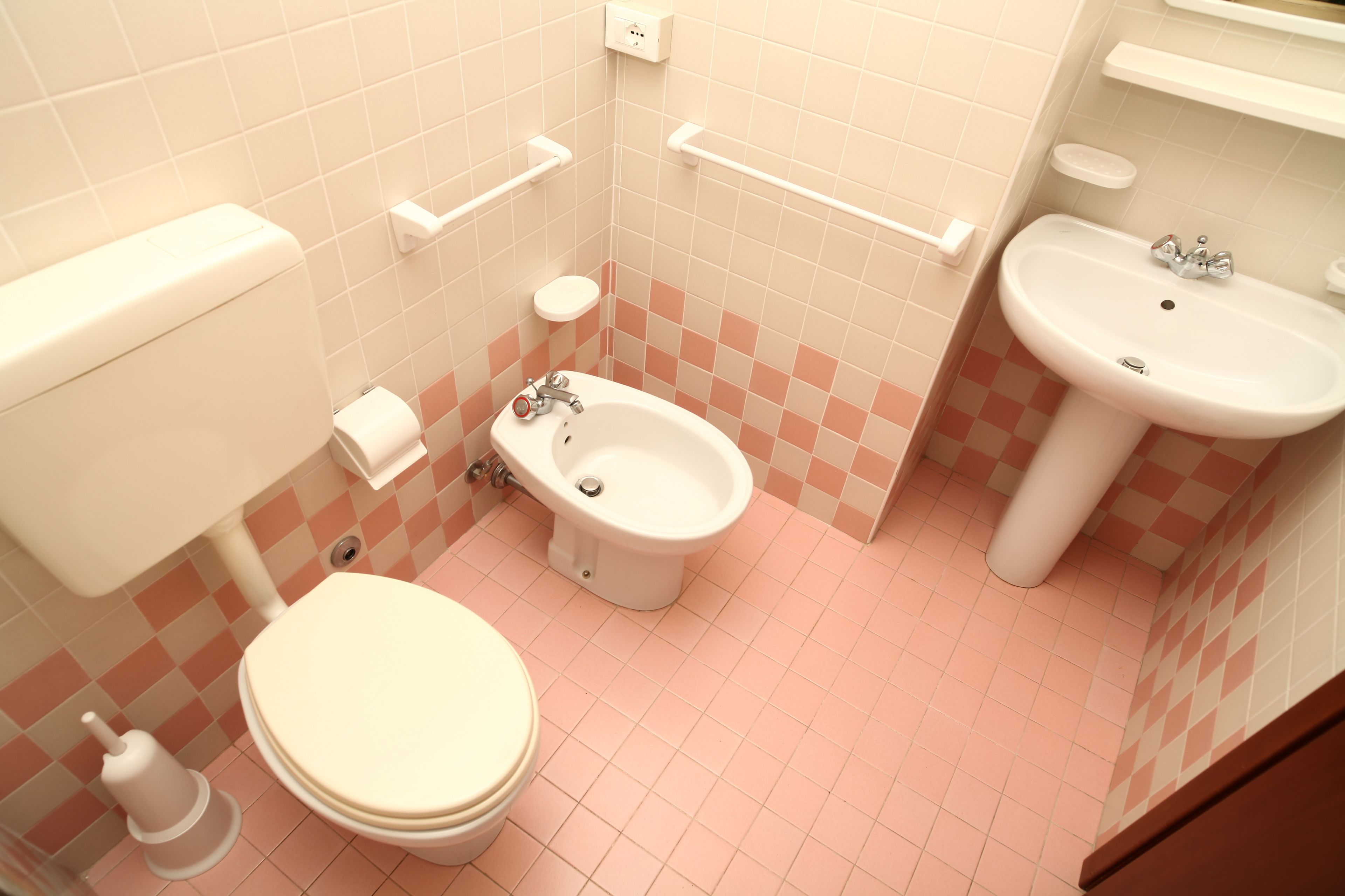 A bathroom with a toilet, bidet, and sink.