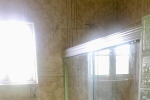 A room with a large window, a glass partition, and a textured wall.