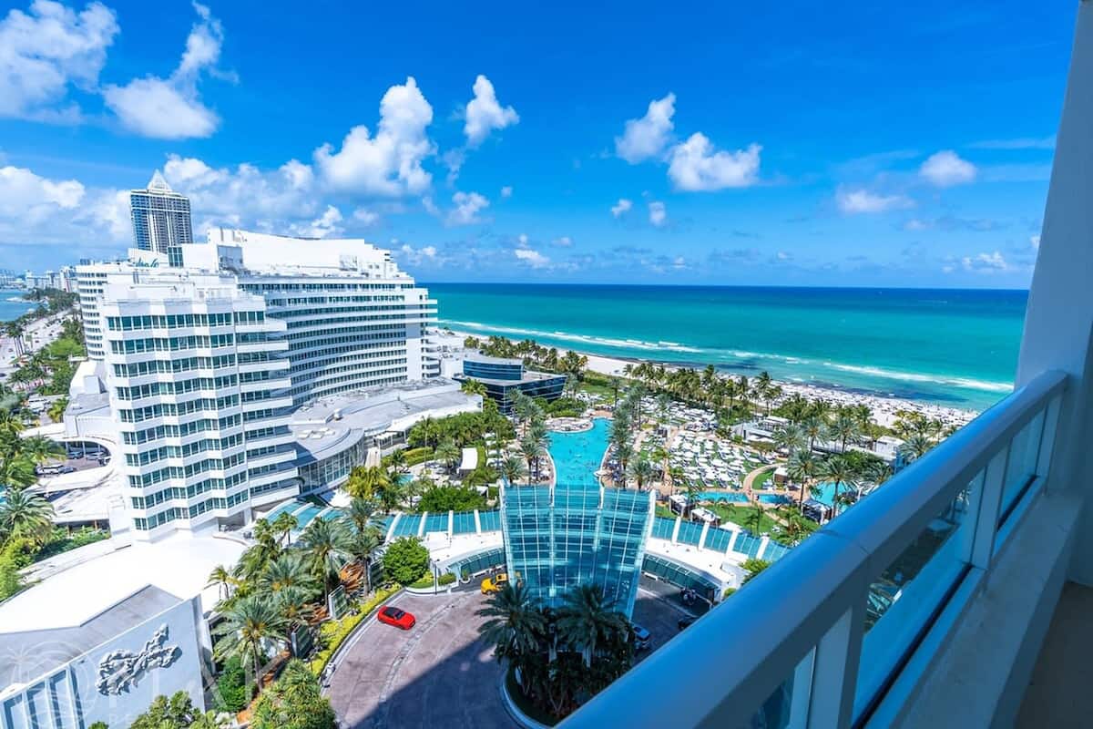 Een hotel met een zwembad, uitzicht op het strand en moderne architectuur.