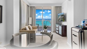Een moderne hotelkamer met balkon, eethoek en kitchenette.