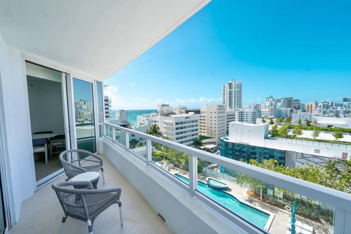 Een balkon met uitzicht op een stadsgezicht en een zwembad.
