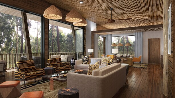 Amplia sala de estar con grandes ventanales, piso de madera y diversas opciones de asientos, incluyendo un sofá y sillones.