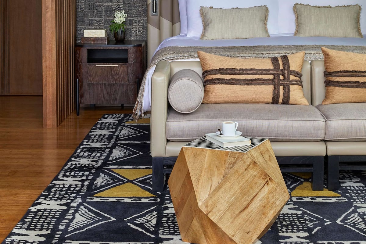 A modern bedroom with a bed, bedside tables, and decorative wall art.