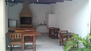 Una cocina con horno de ladrillo, muebles de madera y un refrigerador.