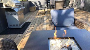 An outdoor patio with a fire feature, seating, and a grill. - Luxurious 8 bd/6ba with ROOFTOP! Price is the total! (Nashville)