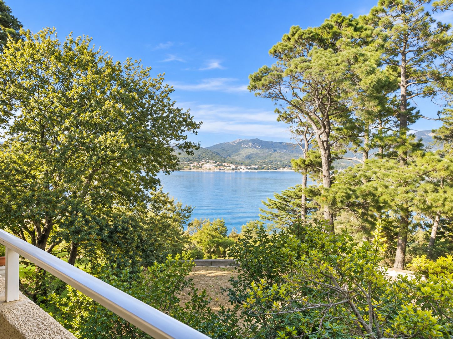 Un paysage côtier offrant une vue dégagée sur la mer et les collines lointaines.