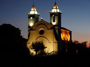 A church with two towers, a clock, and a cross on top.