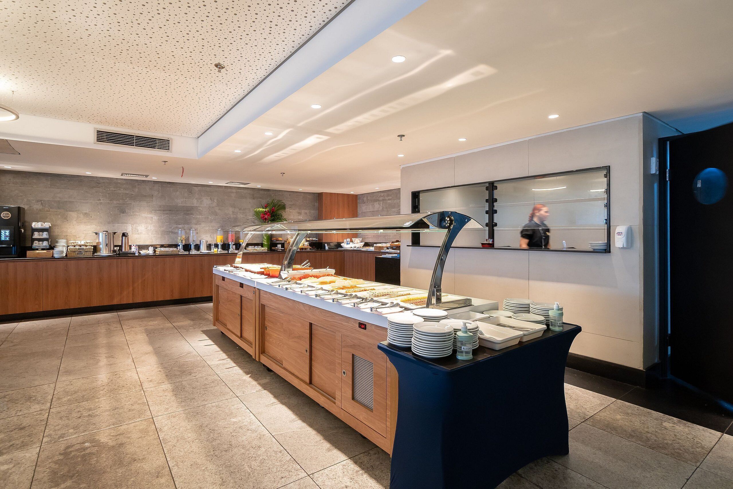 Ein reichhaltiges Buffet mit verschiedenen Speisen, einer Kaffeemaschine und einer Theke mit digitaler Anzeige.