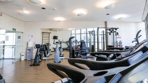 A gym with treadmills, stationary bikes, and weight machines. - HY Beach Flats - International (Recife)