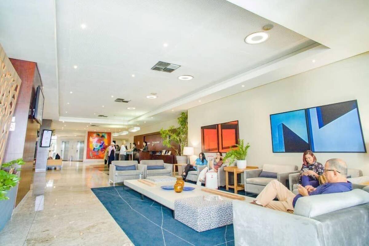 A spacious lobby with seating areas, a reception desk, and artwork on the walls.
