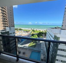 Um edifício alto com vista para uma praia e oceano.