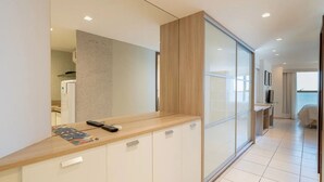 A modern hotel room with a kitchenette, a large window, and a view of the sea. - HY Beach Flats - International (Recife)