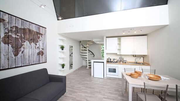 Eine moderne Wohnung mit Wohnbereich, Küche und Essbereich.