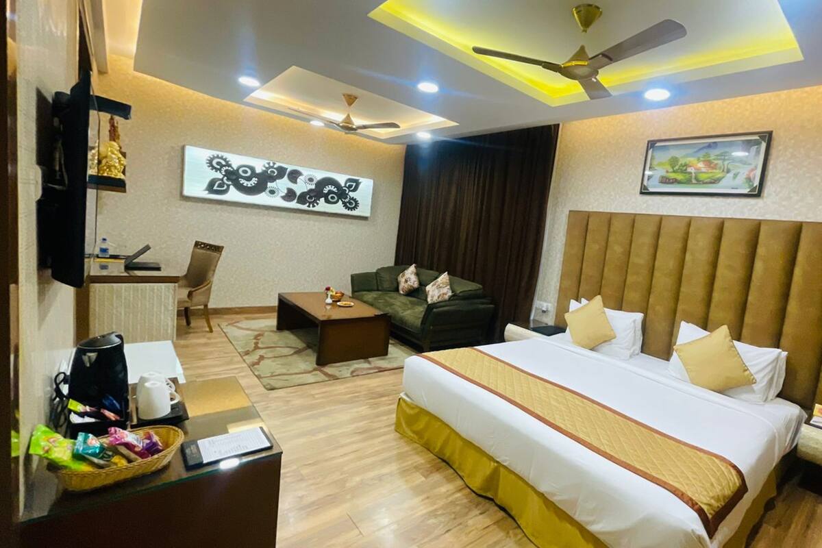 A hotel room with a large bed, a desk with a chair, a coffee maker, and a television.