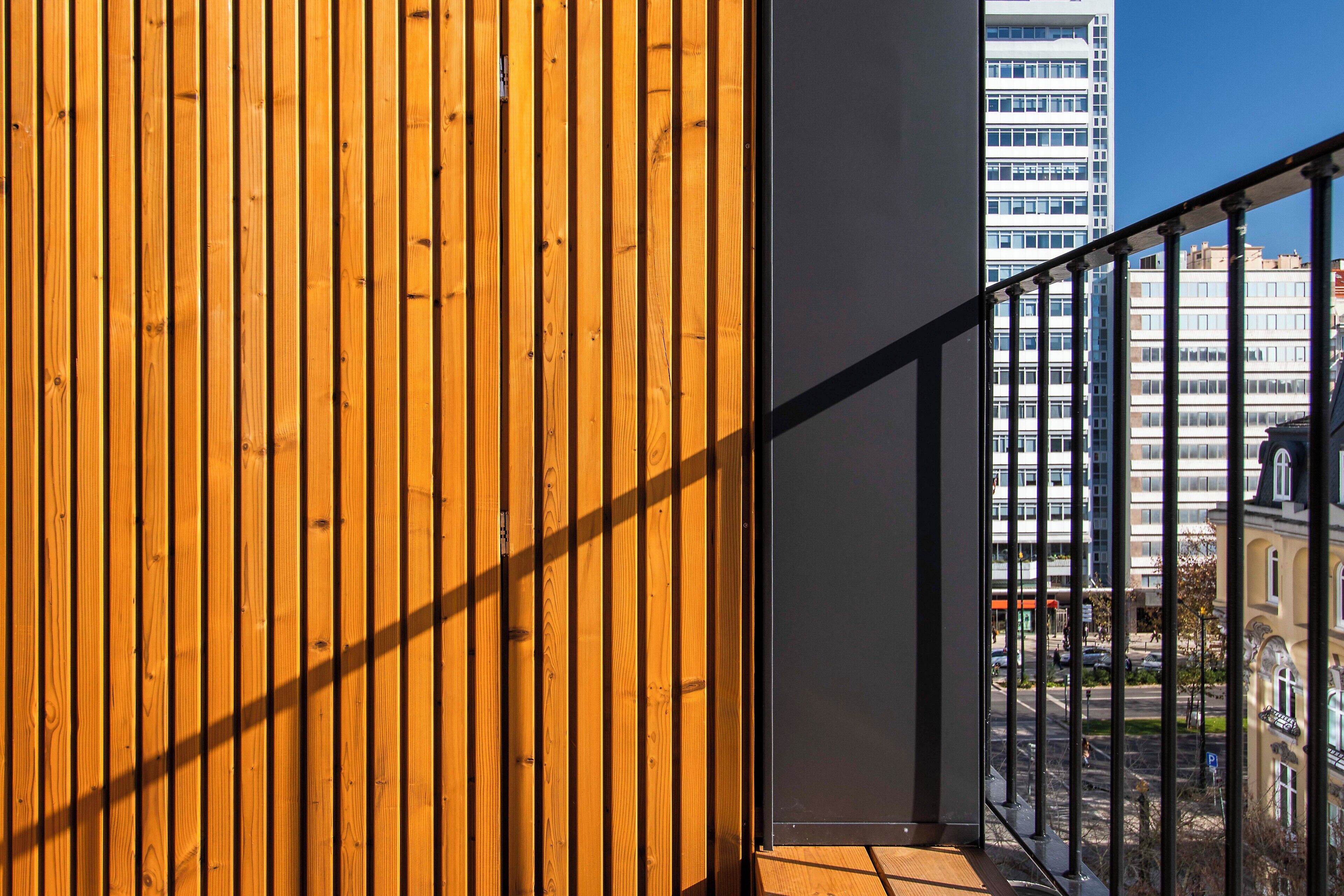 A wooden panel wall with a view of a cityscape through a window.